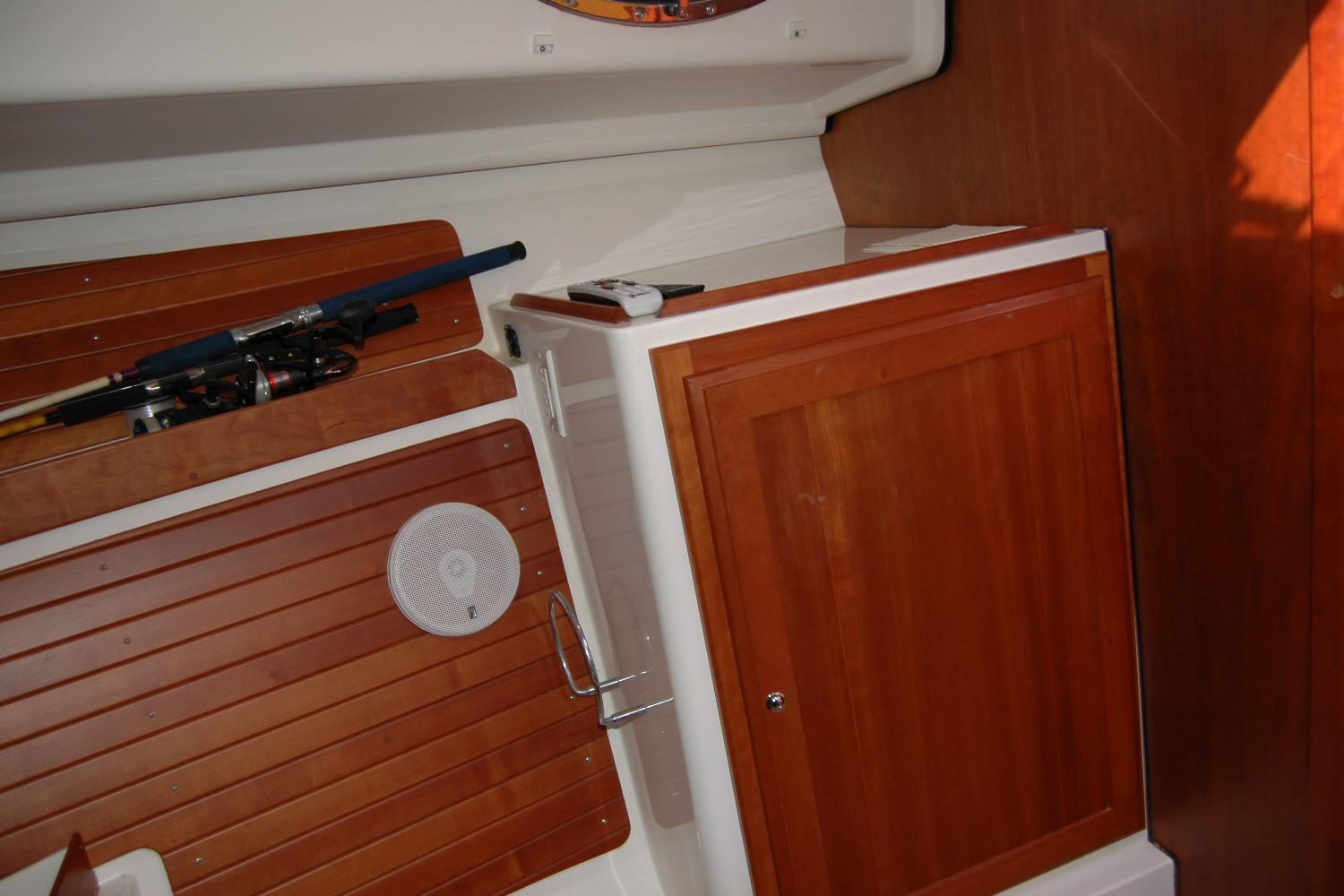 Interior of 2014 Back Cove 34 boat with wooden cabinetry and fishing rods.