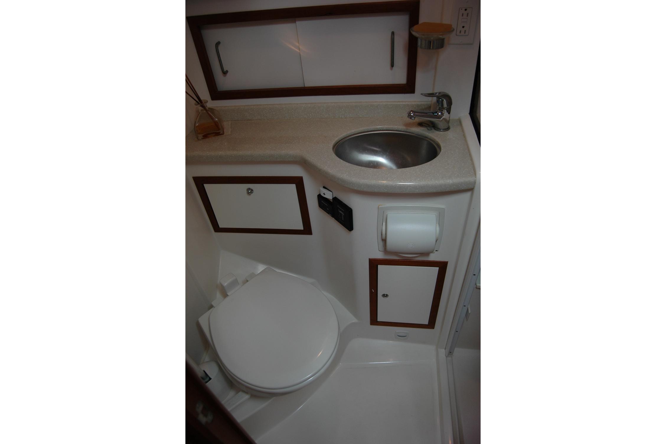 2014 Back Cove 34 yacht bathroom with sink, toilet, and storage cabinets.