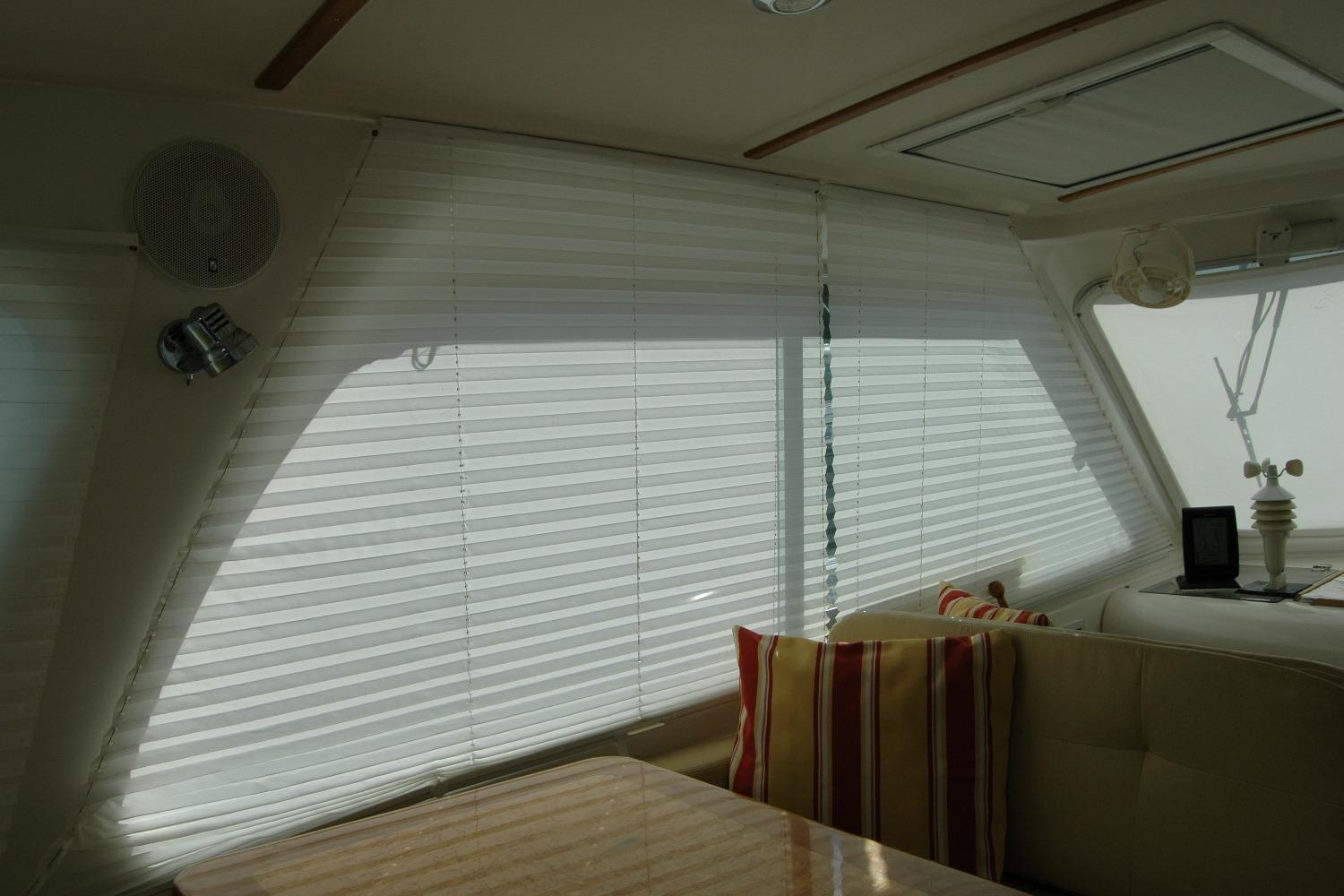 Interior of 2014 Back Cove 34 yacht with blinds and striped cushions.