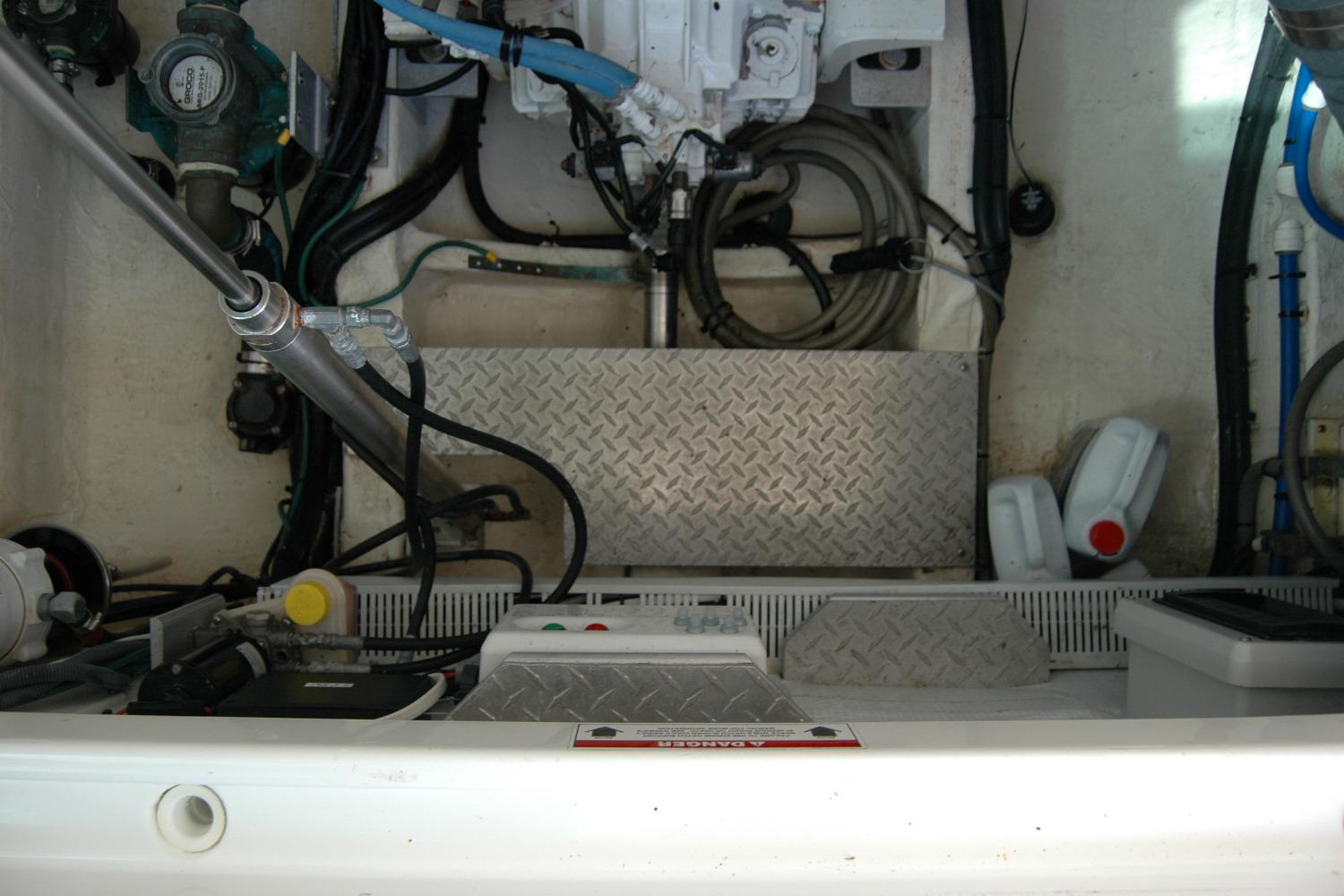 Engine compartment of a 2014 Back Cove 34 boat, featuring mechanical components and storage.