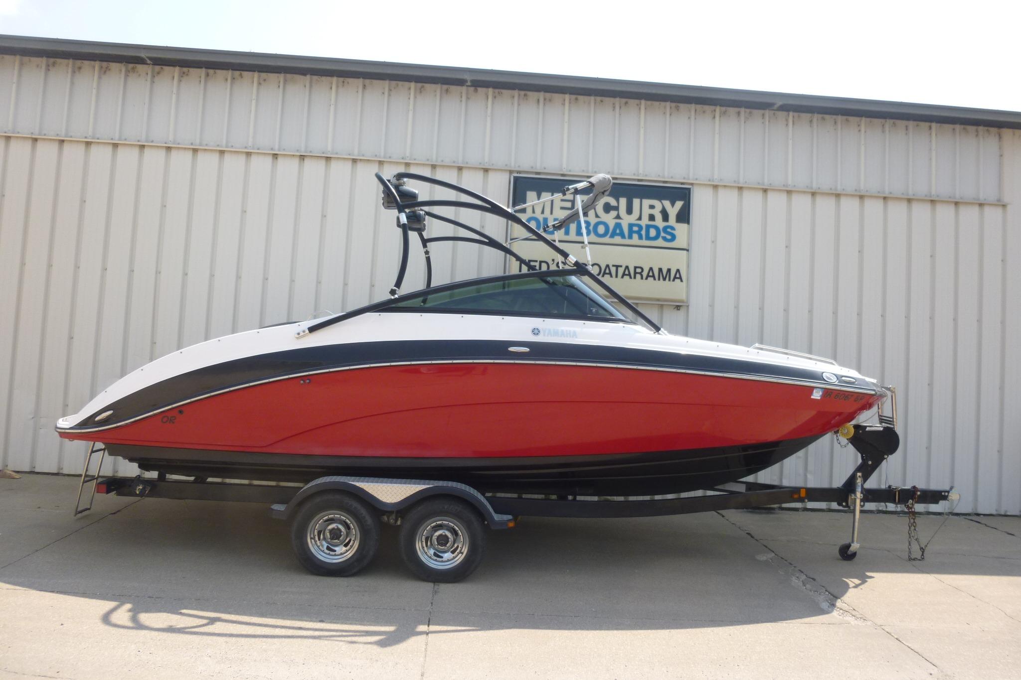 2014 Yamaha Boats 240, red and white, on trailer outside a building.
