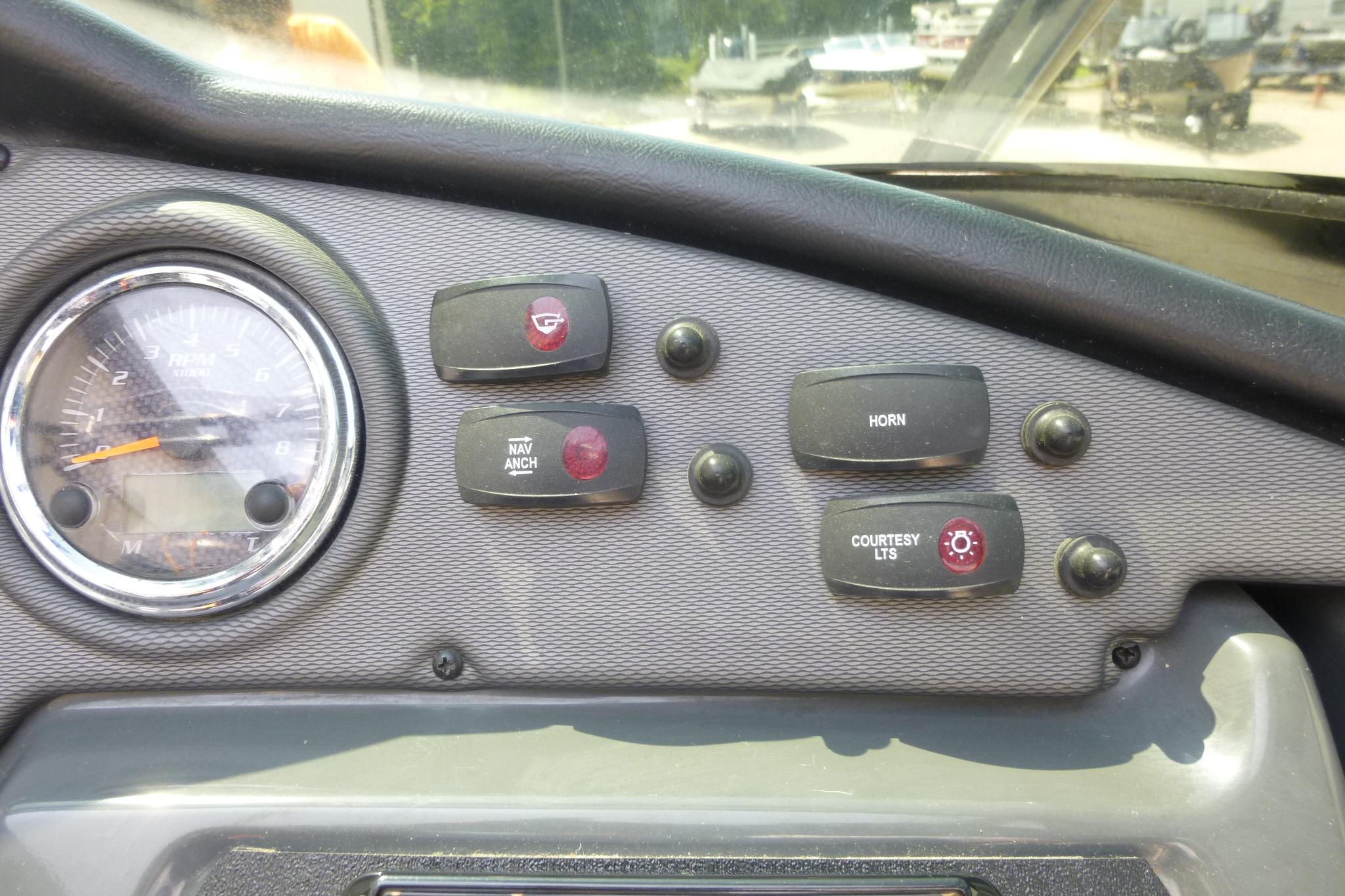 Dashboard controls of a 2014 Yamaha Boats 240, featuring switches and a gauge.