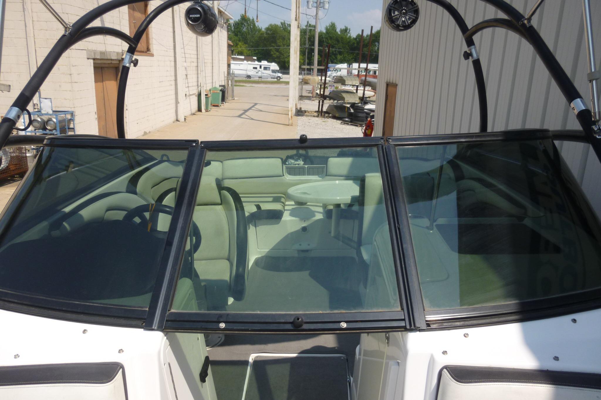 2014 Yamaha Boats 240 with sleek windshield and spacious interior, parked outdoors.