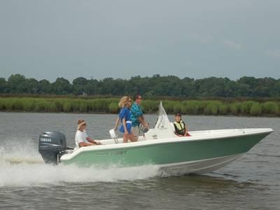2014 Key West 189FS boat cruising on a river with passengers.