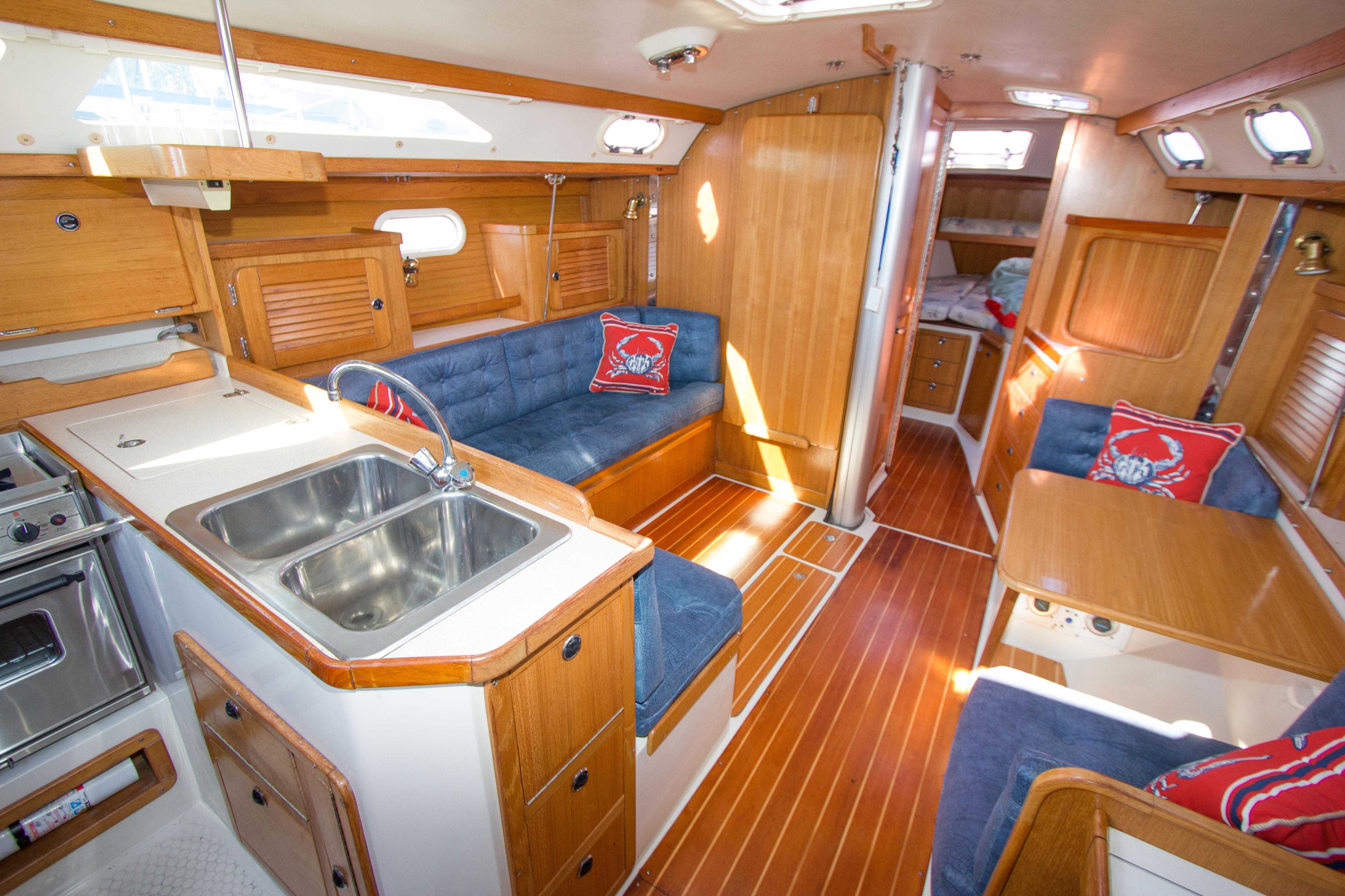 Interior of 2001 Catalina MK II sailboat with wood finish and blue seating.