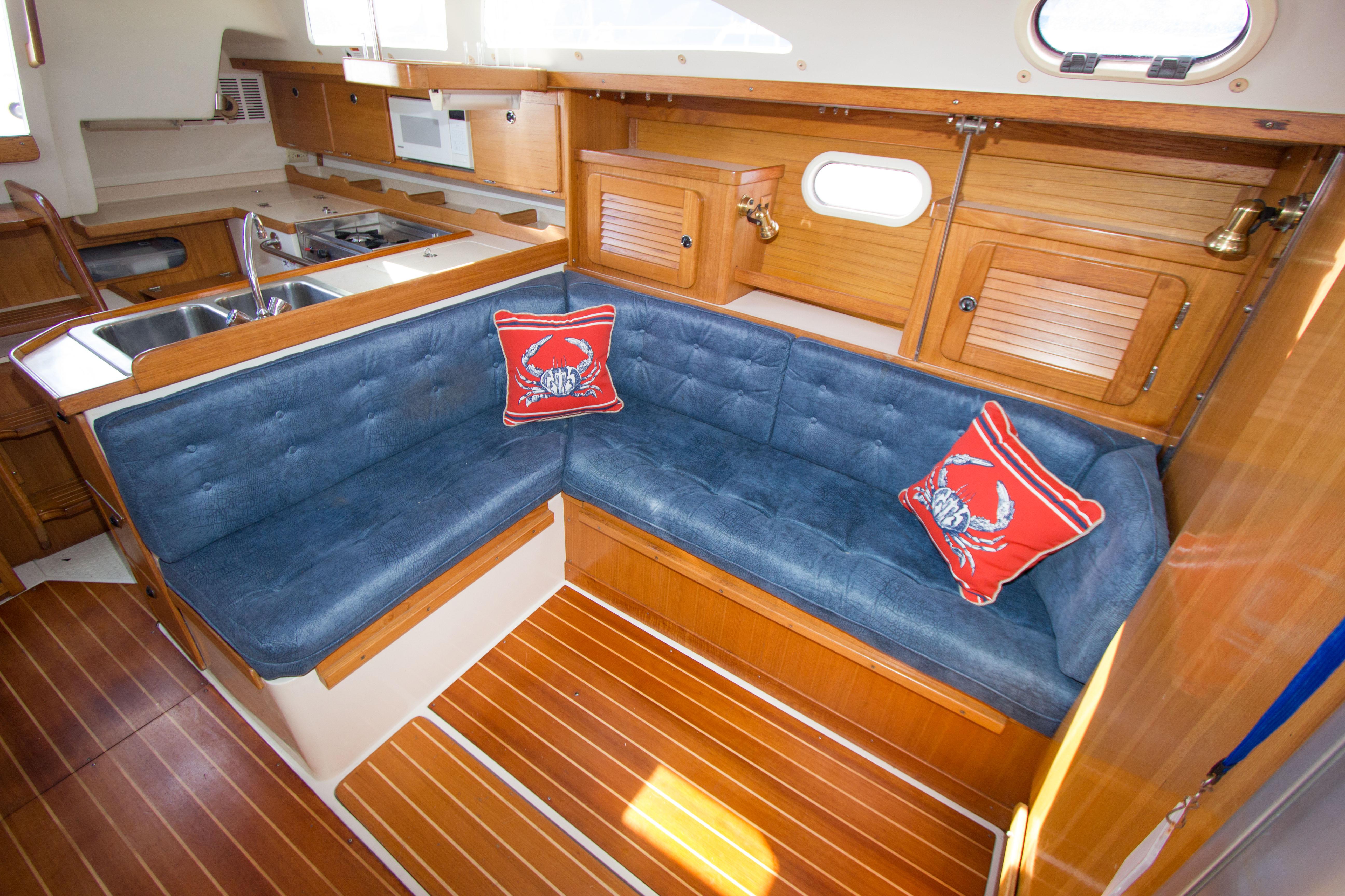 Interior of 2001 Catalina MK II sailboat with blue seating and wooden cabinetry.