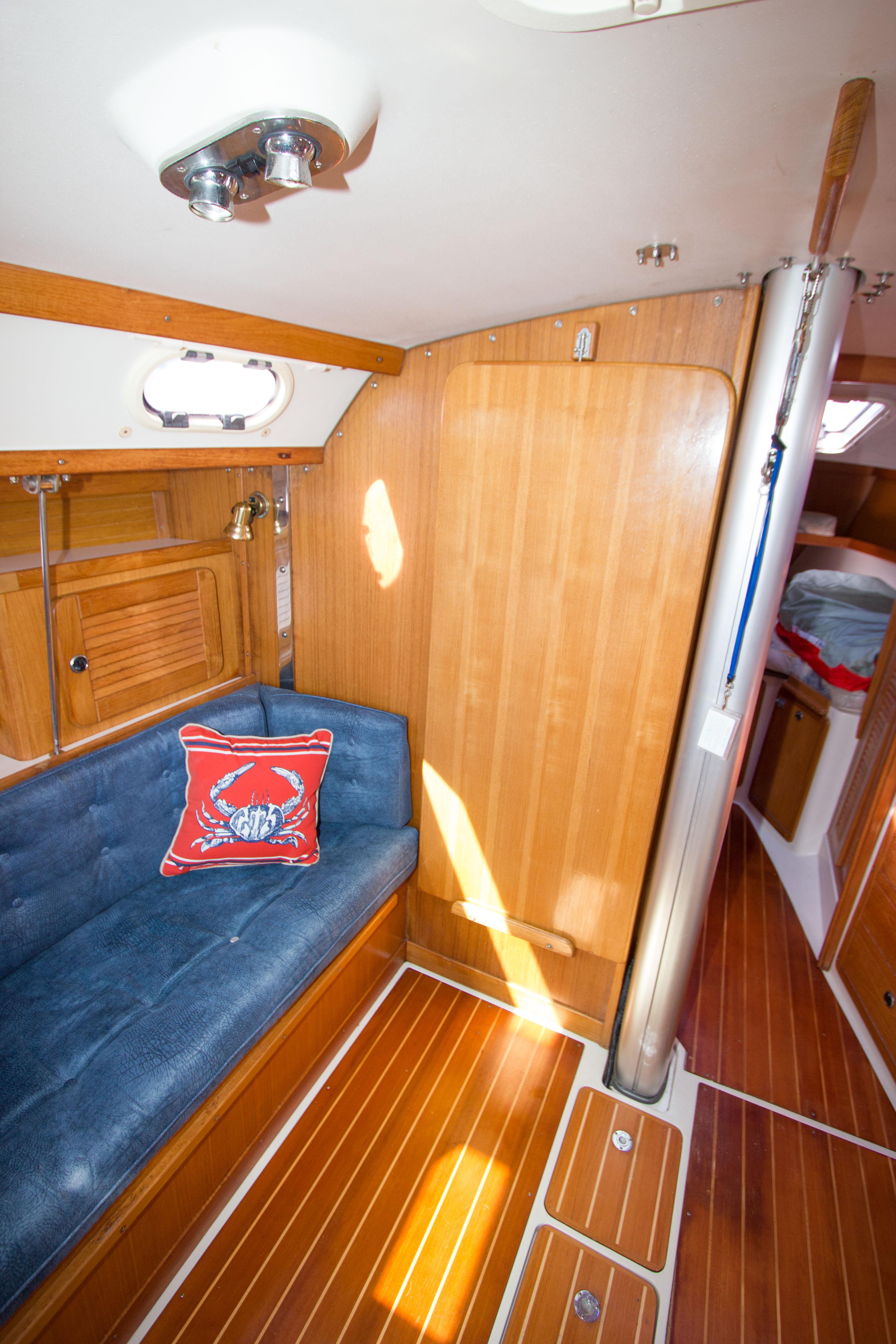 Interior of 2001 Catalina MK II sailboat with wooden paneling and blue cushioned seating.
