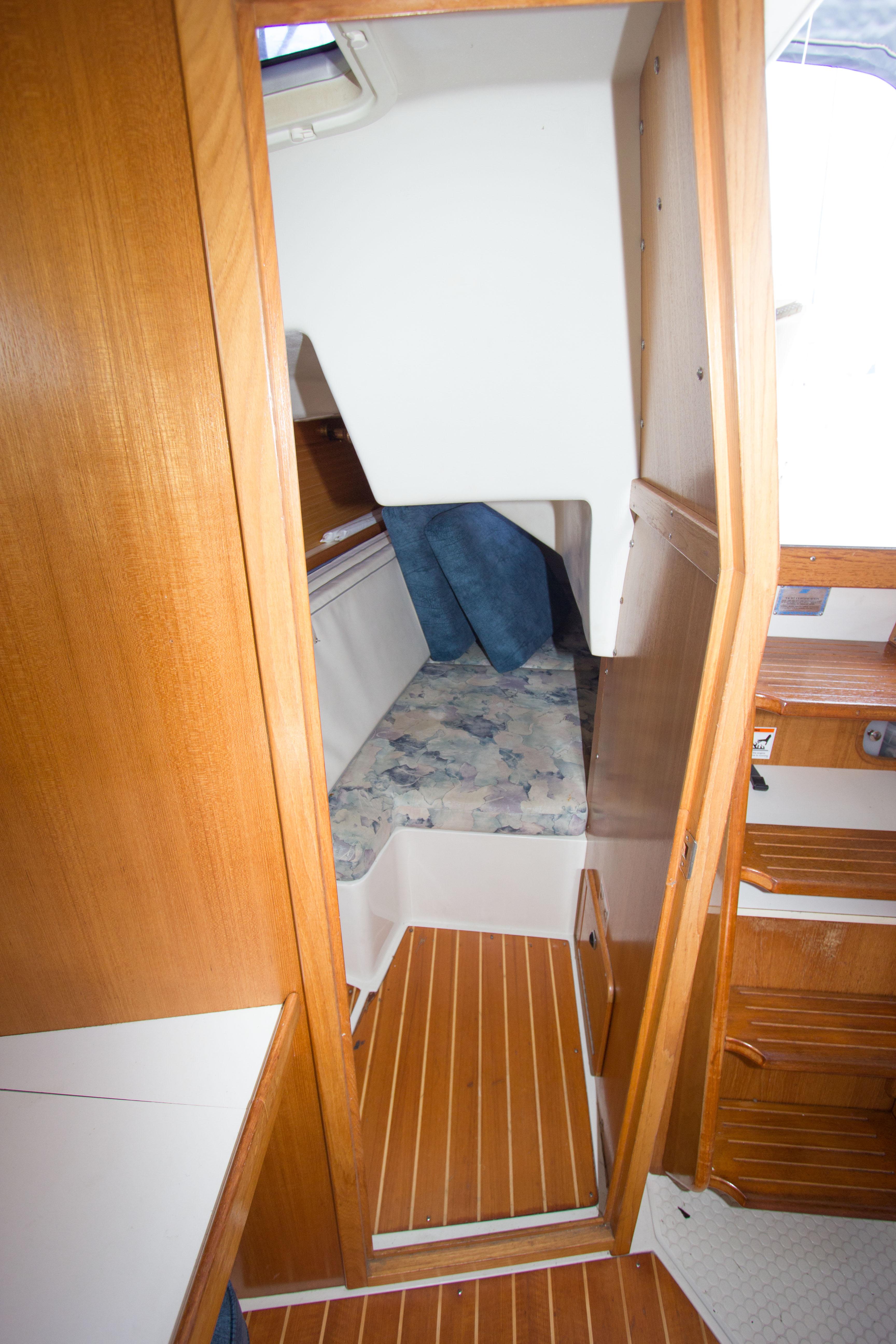 Interior view of 2001 Catalina MK II sailboat cabin with wooden flooring and cozy sleeping area.