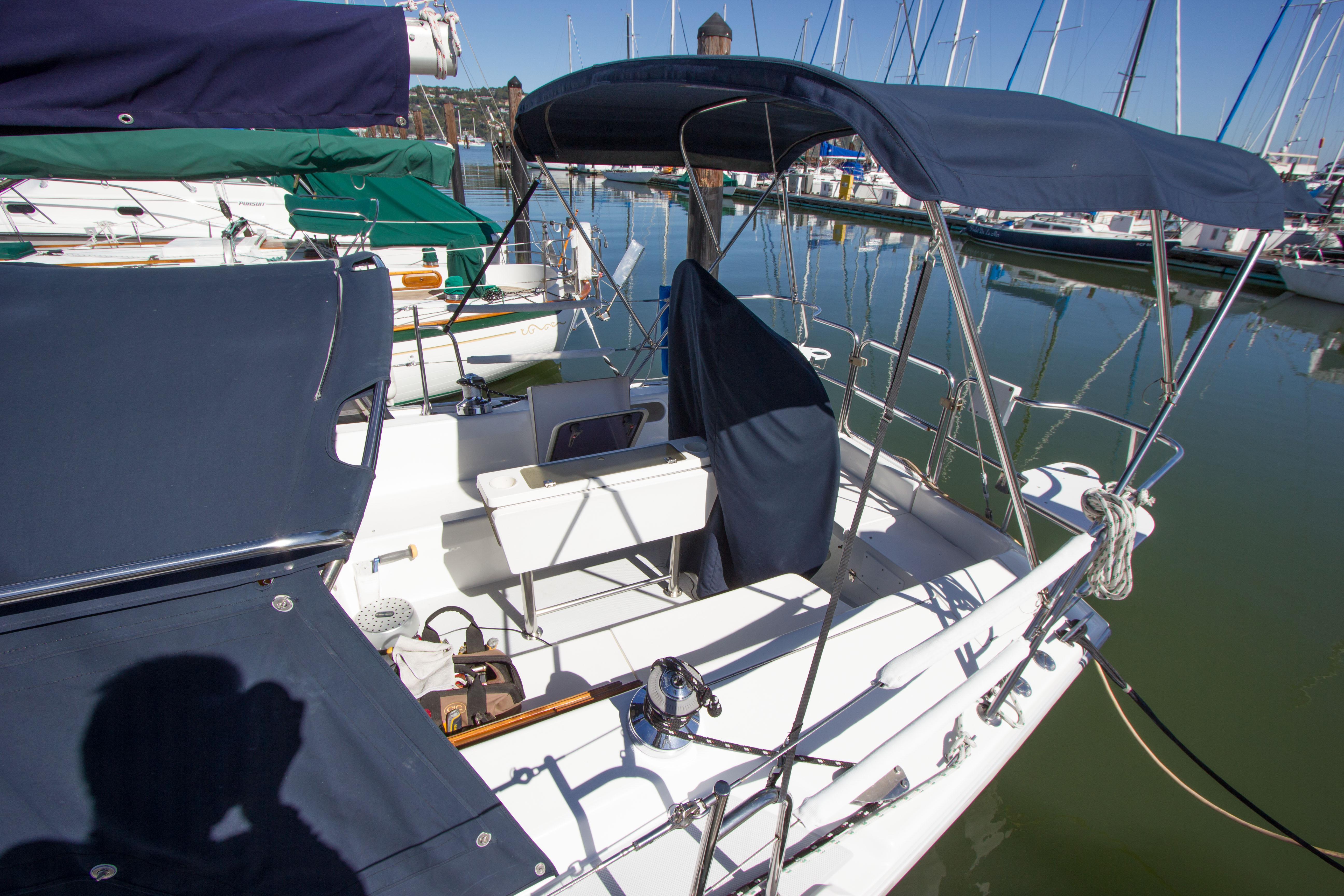 Catalina MK II 2001 sailboat docked in marina, featuring blue canopy and clean deck.