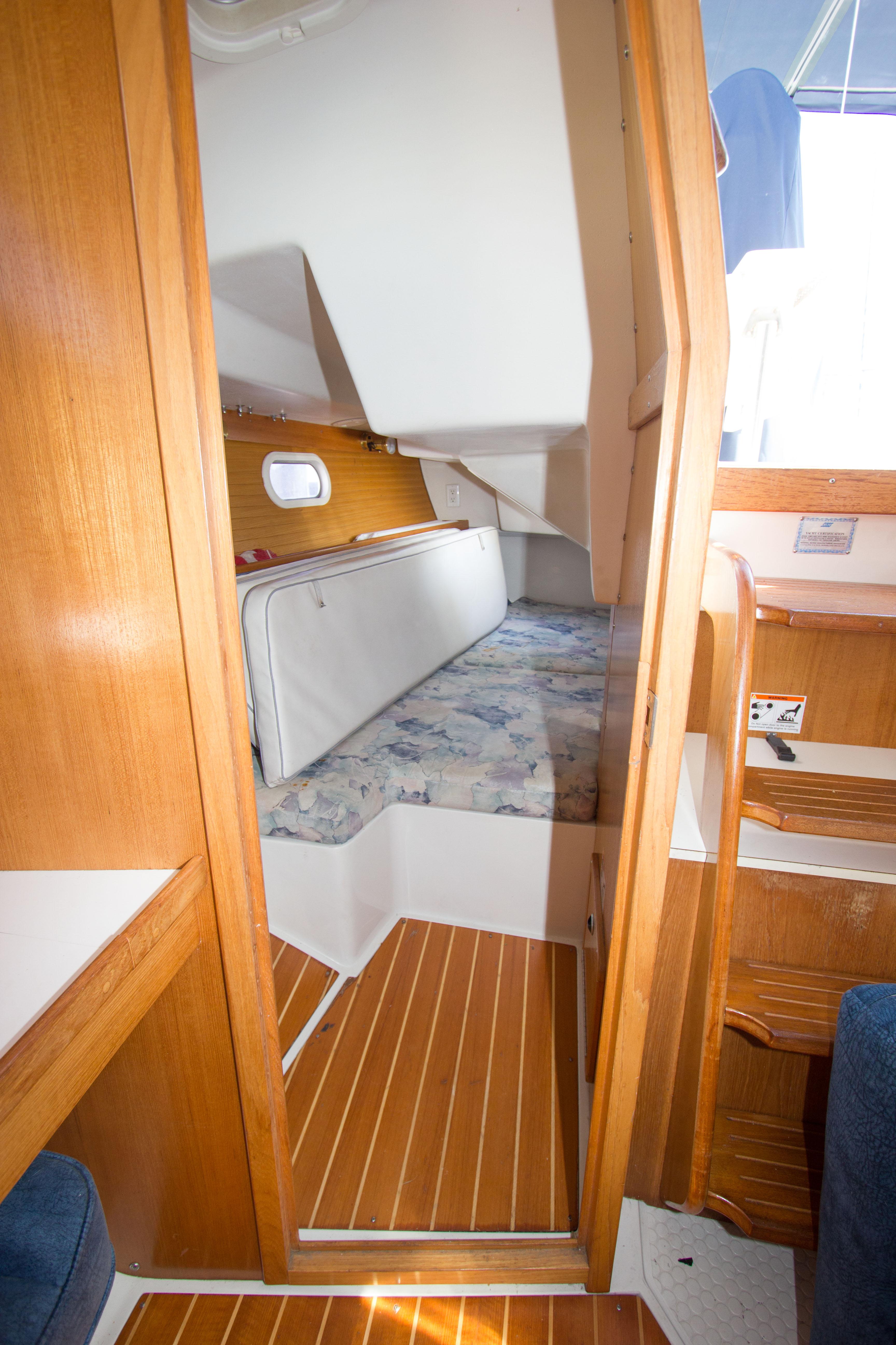 Interior cabin of 2001 Catalina MK II sailboat with wooden finishes and cozy sleeping area.