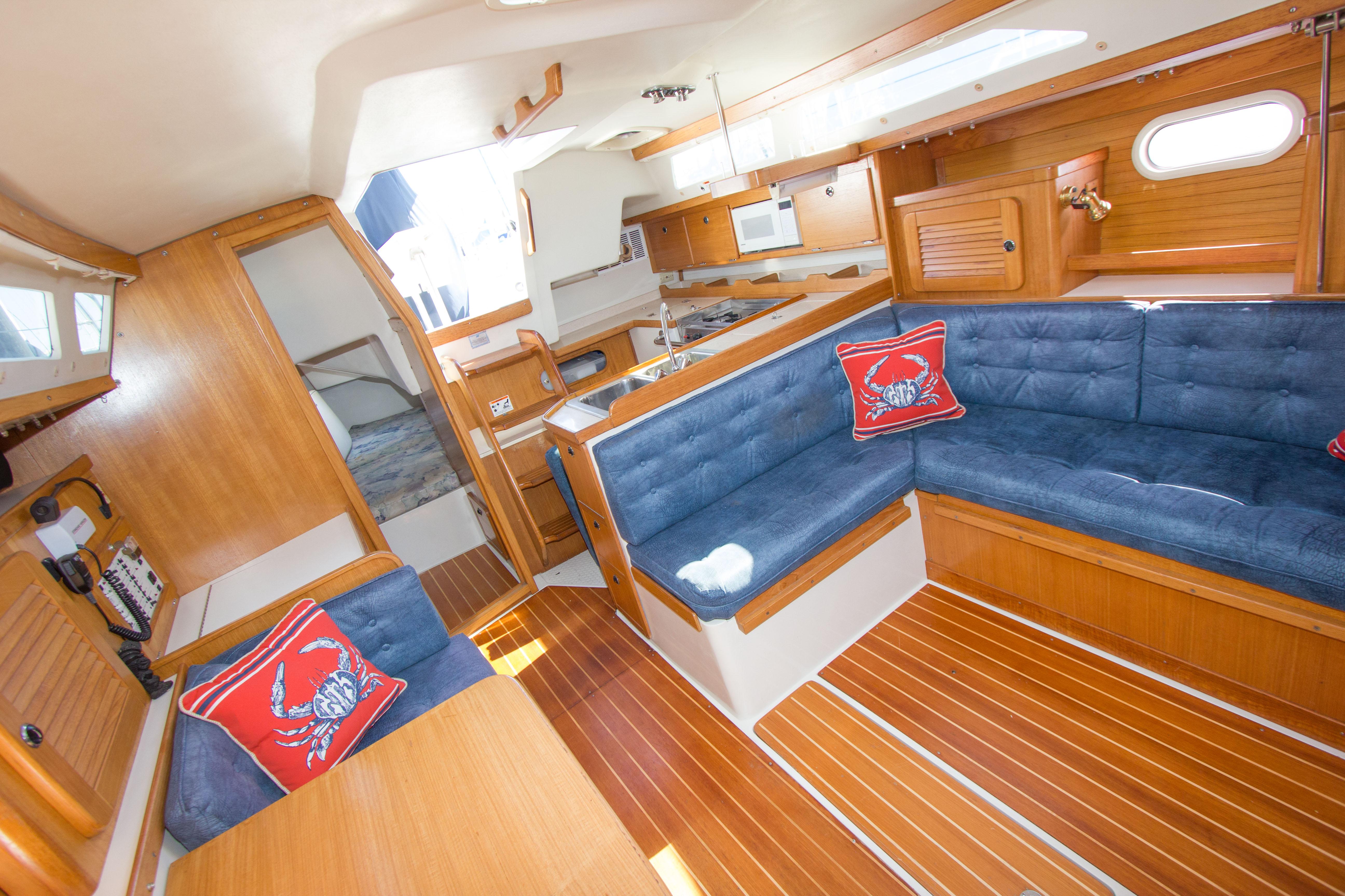 Interior of 2001 Catalina MK II sailboat with blue seating and wooden finishes.