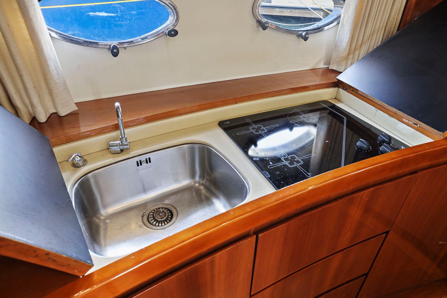 Princess-65 2003-DISMISSED CA-US-Kitchen area of a 2003 Princess 65 yacht with sink and stove.-8801006 | Thumbnail