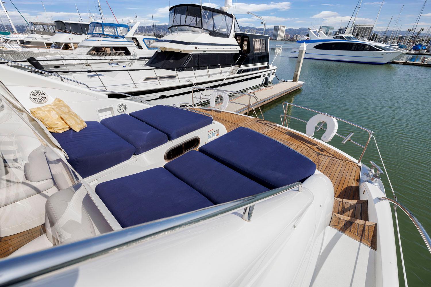 Princess-65 2003-DISMISSED CA-US-Luxurious 2003 Princess 65 yacht with blue sunbeds docked at a marina.-8801006 | Thumbnail