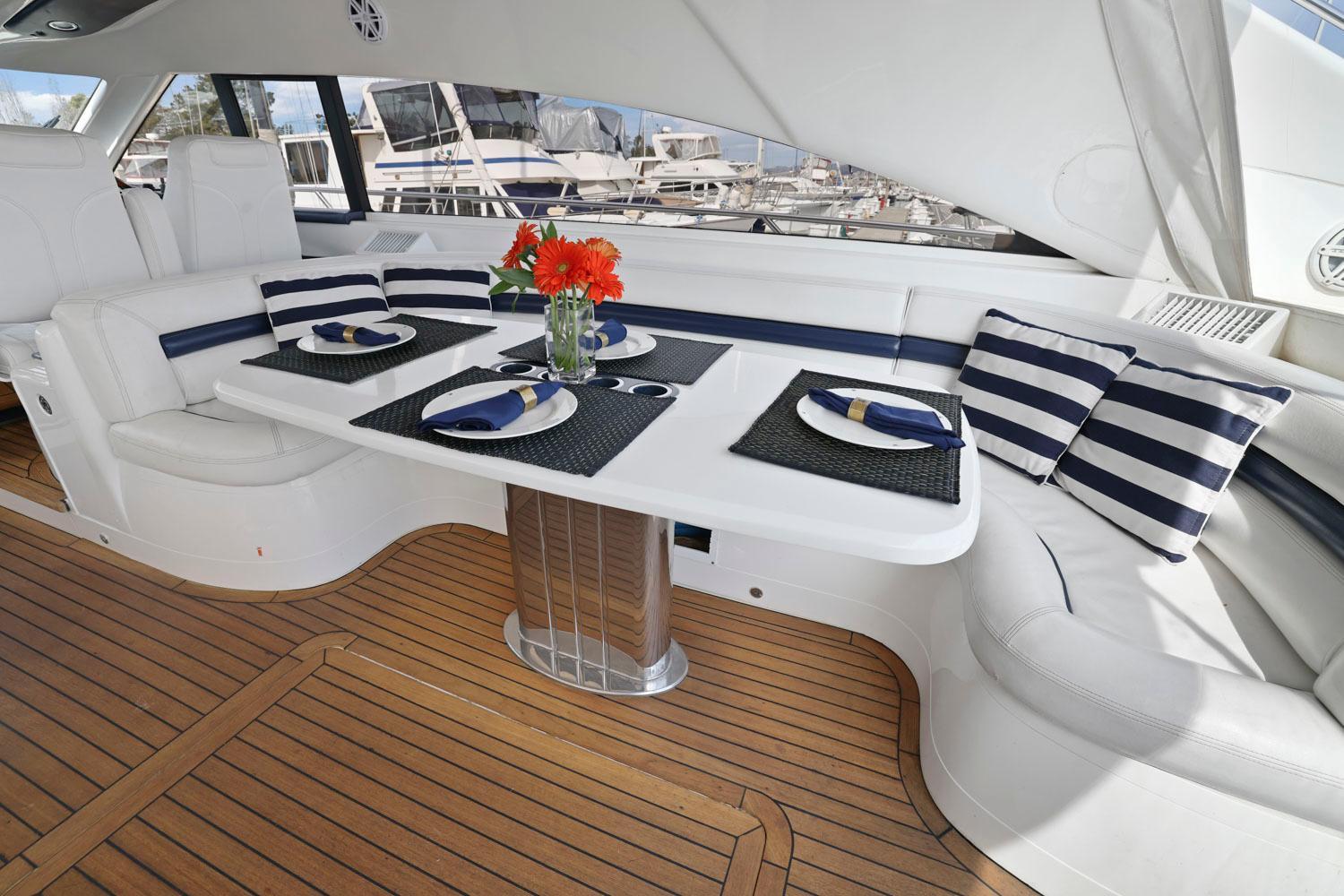 Princess-65 2003-DISMISSED CA-US-Luxurious 2003 Princess 65 yacht interior with elegant dining setup and striped cushions.-8801006 | Thumbnail