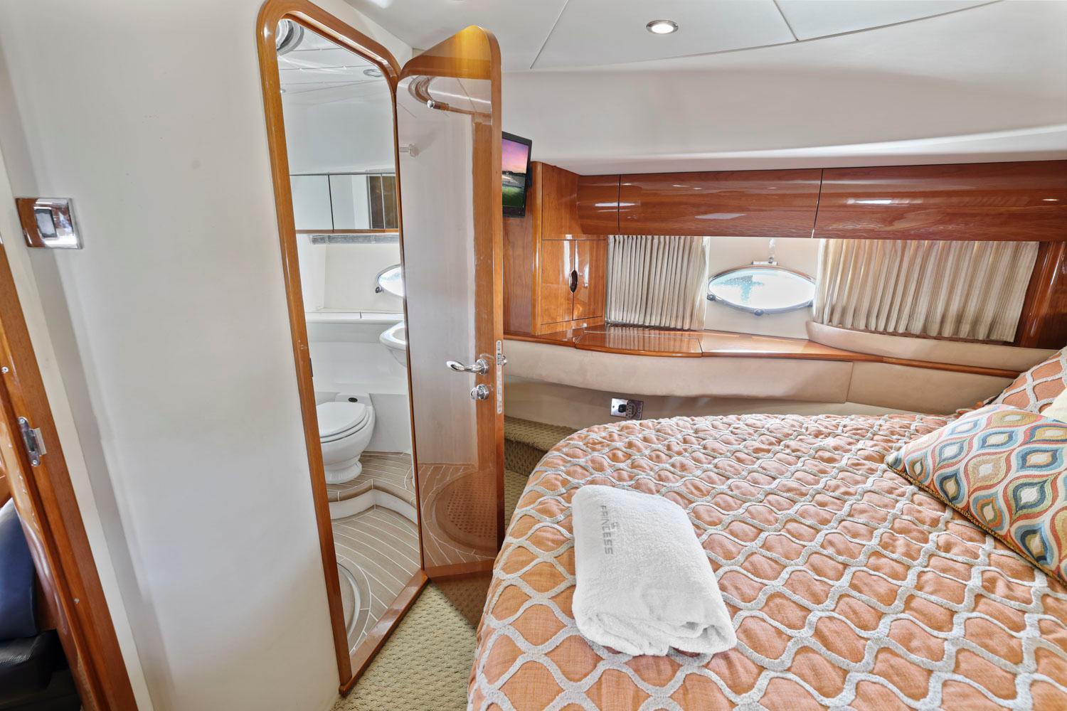 Princess-65 2003-DISMISSED CA-US-Luxurious 2003 Princess 65 yacht bedroom with ensuite bathroom, elegant wood finishes, and cozy bedding.-8801006 | Thumbnail