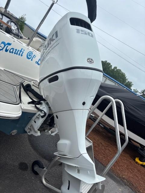 2021 Stingray 212 SC boat with Suzuki 150 outboard motor, docked on trailer.