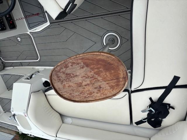 2021 Stingray 212 SC boat interior with beige seating and wooden table.