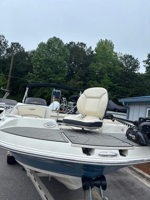 2021 Stingray 212 SC boat with white seating, docked outdoors.