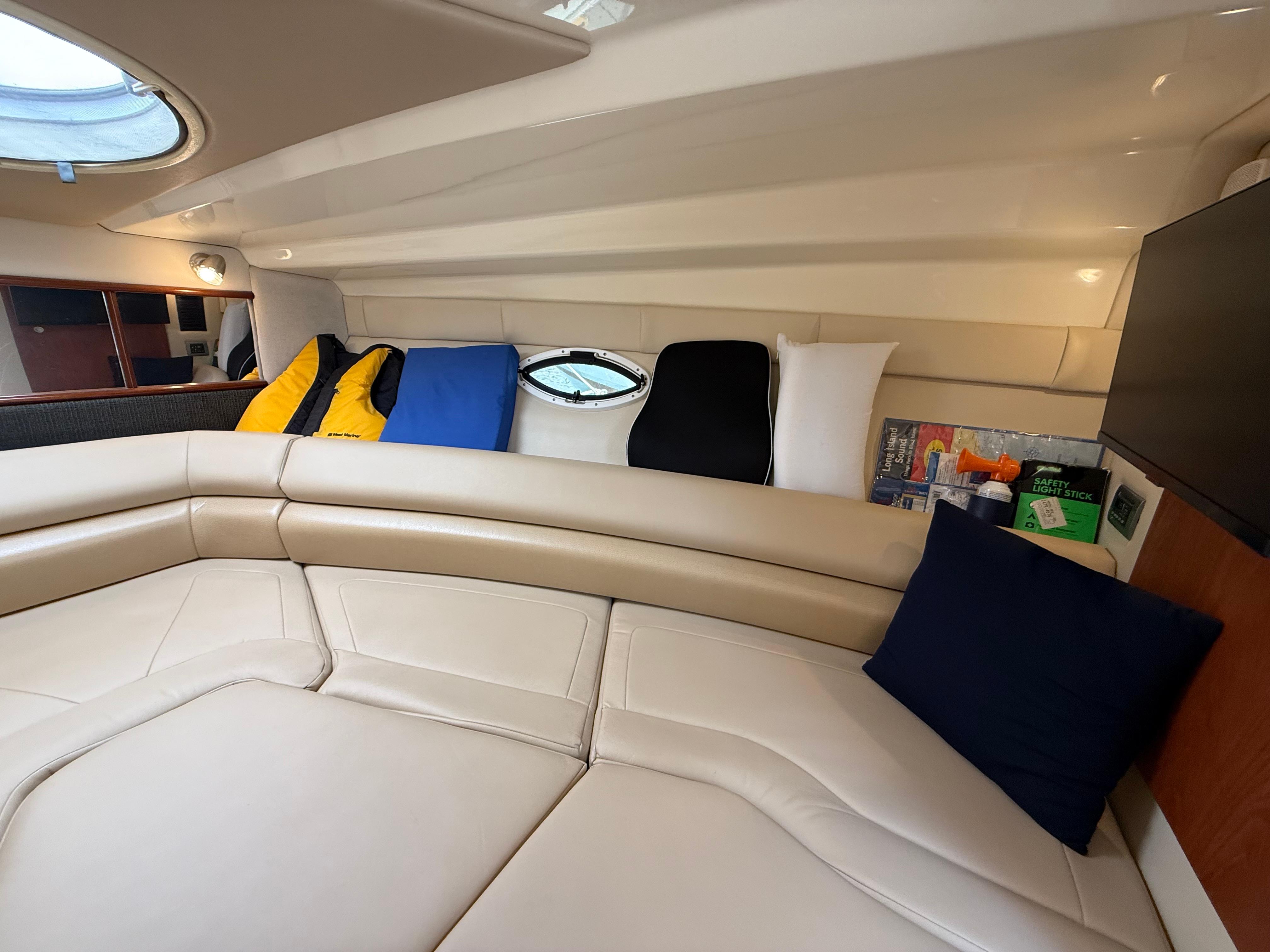 Interior of 2009 Monterey 280 SCR boat with beige seating and colorful cushions.