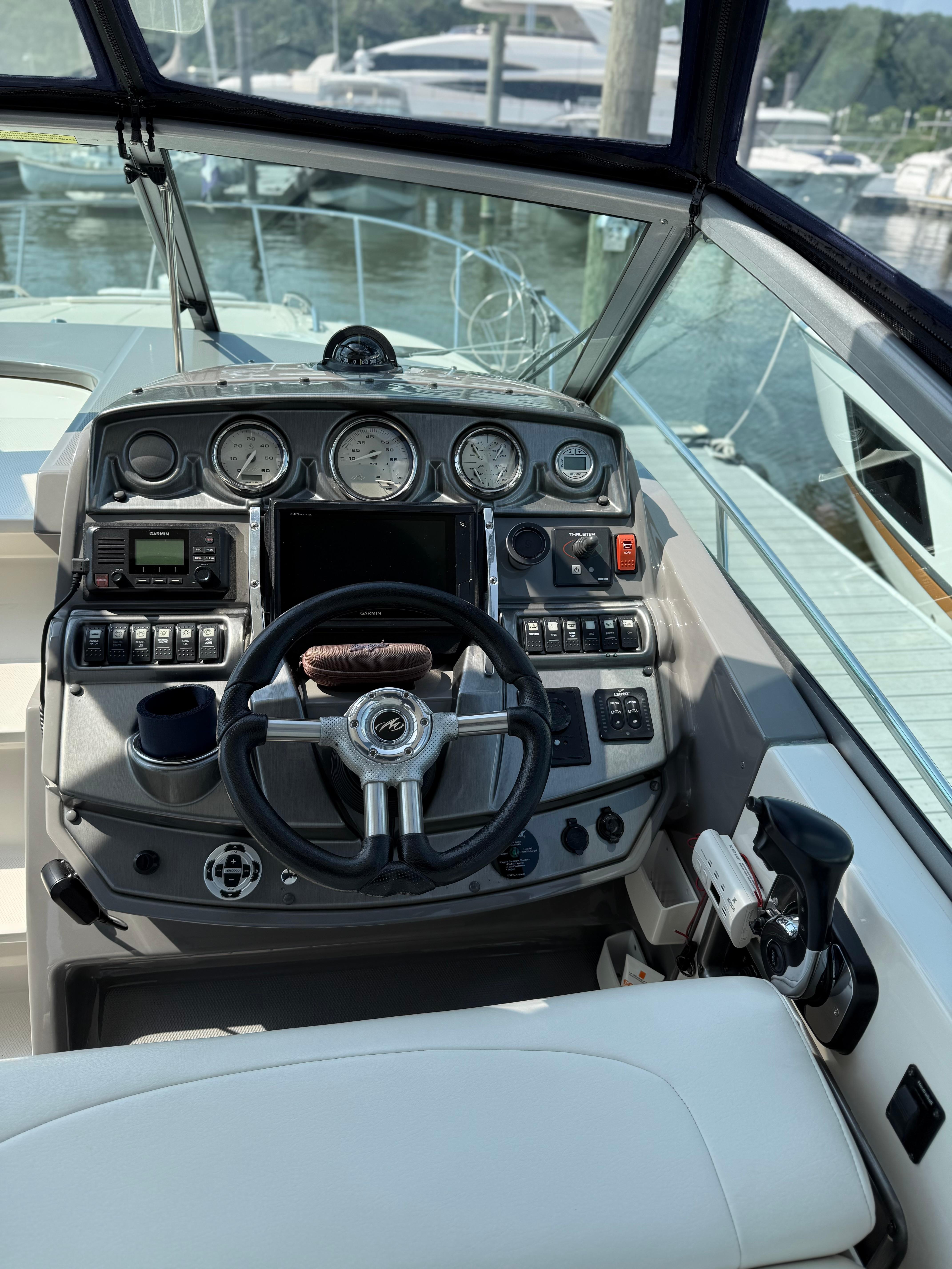 Cockpit of 2009 Monterey 280 SCR boat with steering wheel and control panel.