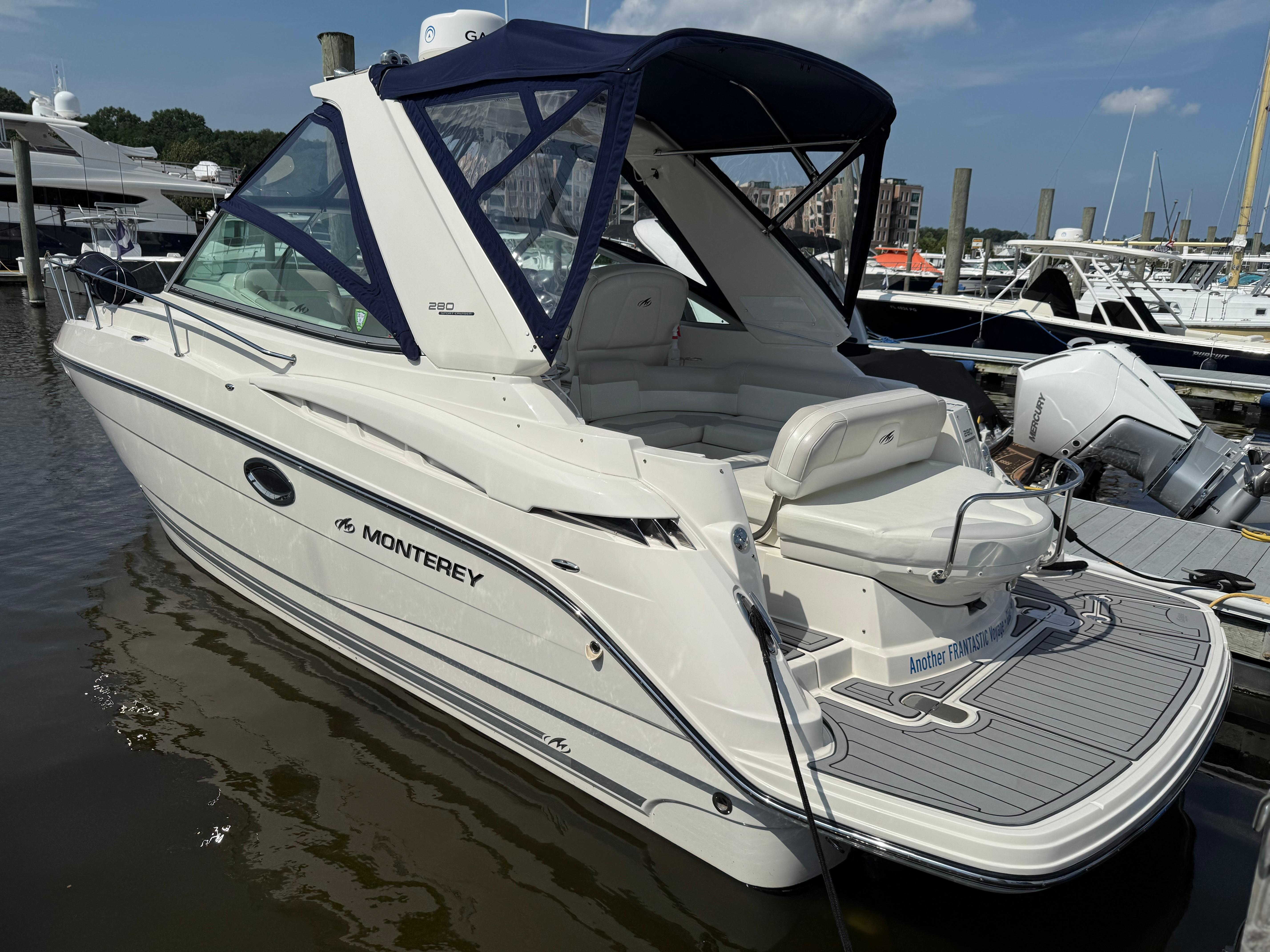2009 Monterey 280 SCR boat docked at marina, featuring sleek design and spacious seating.