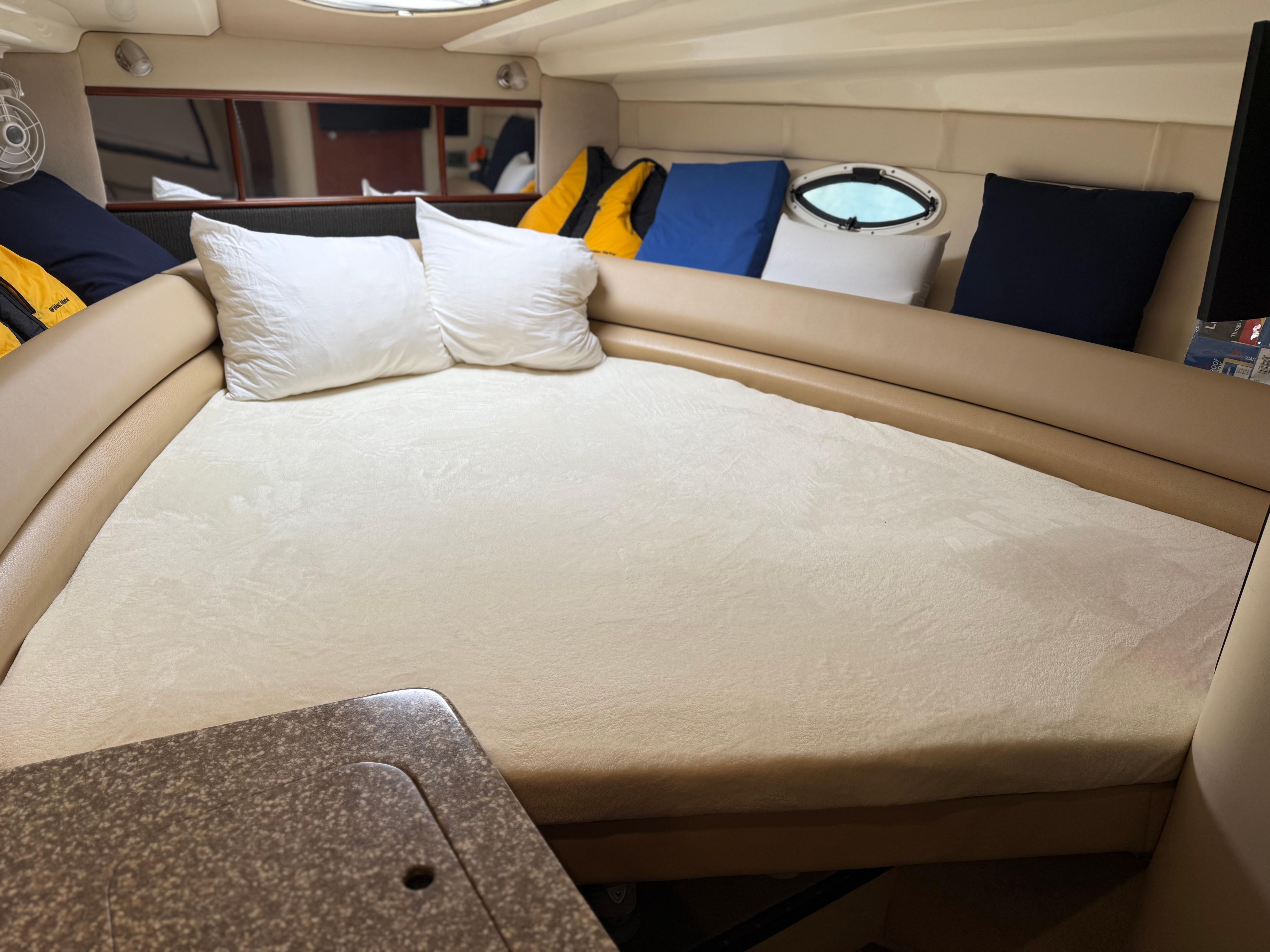 2009 Monterey 280 SCR cabin interior with bed, pillows, and porthole window.