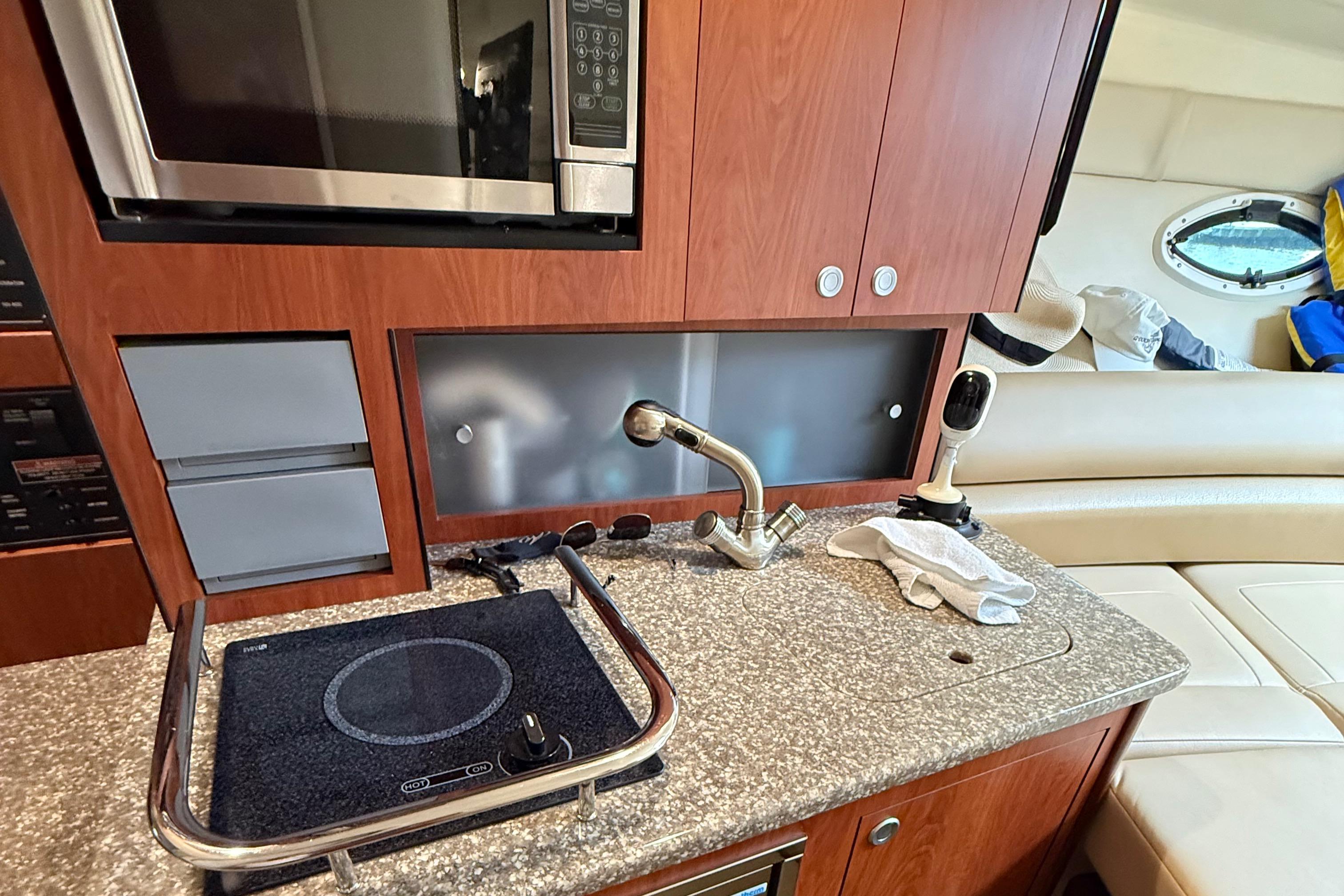 2009 Monterey 280 SCR yacht kitchen with microwave, stove, and sink.