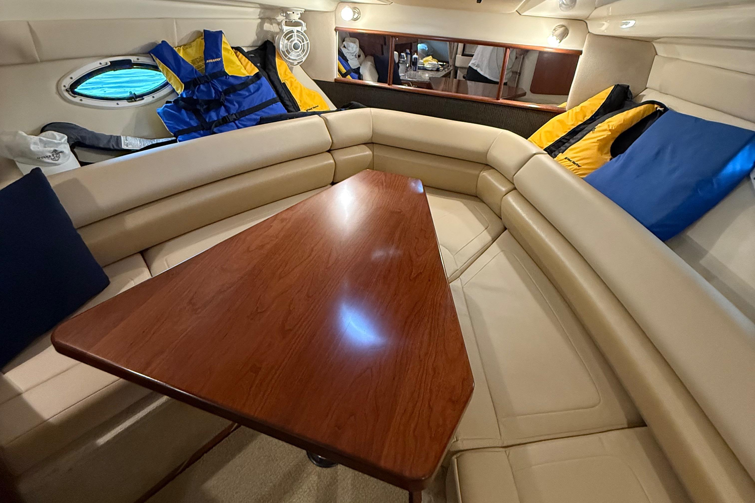 Interior of 2009 Monterey 280 SCR boat with beige seating and wooden table.