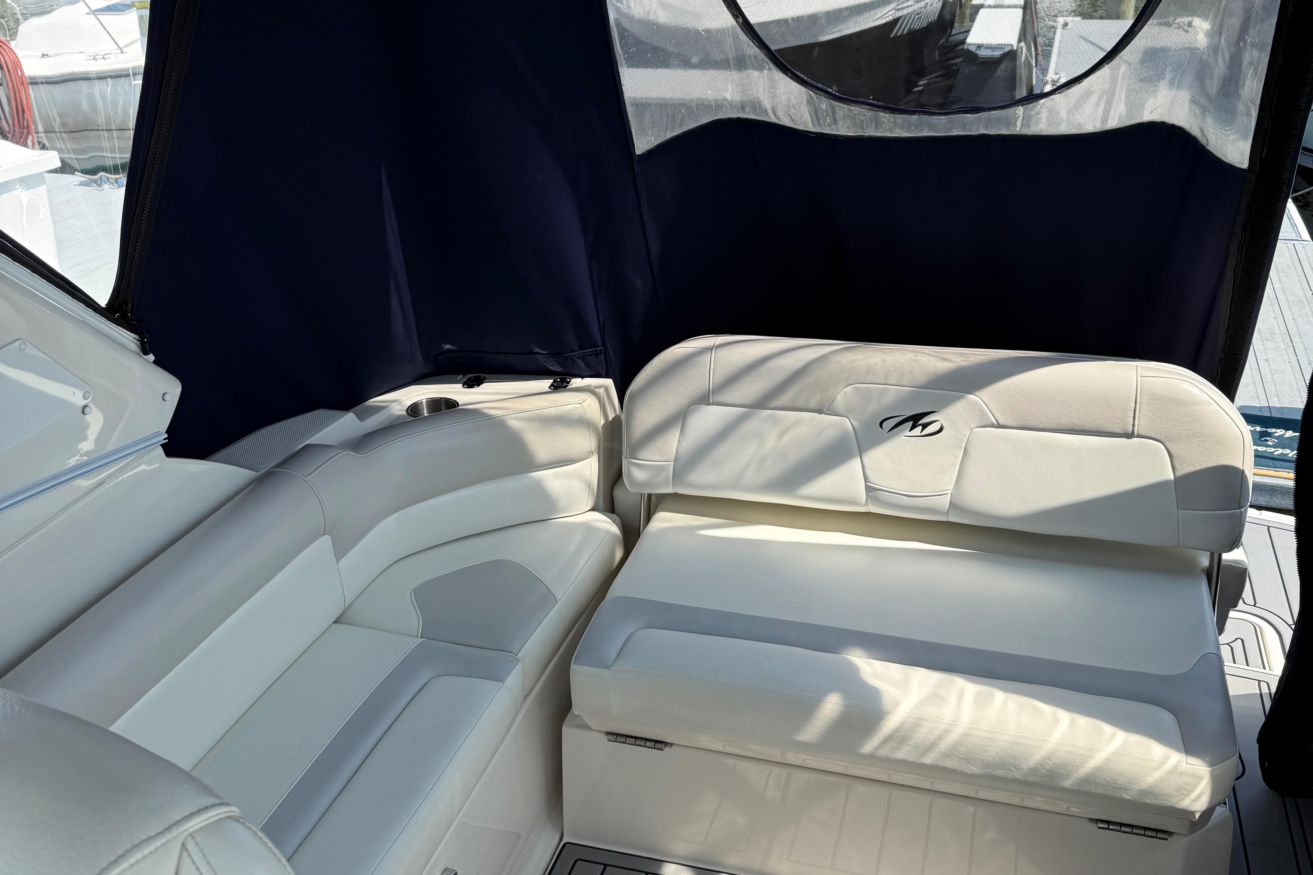 Interior of 2009 Monterey 280 SCR boat with white leather seating and dark blue canopy.