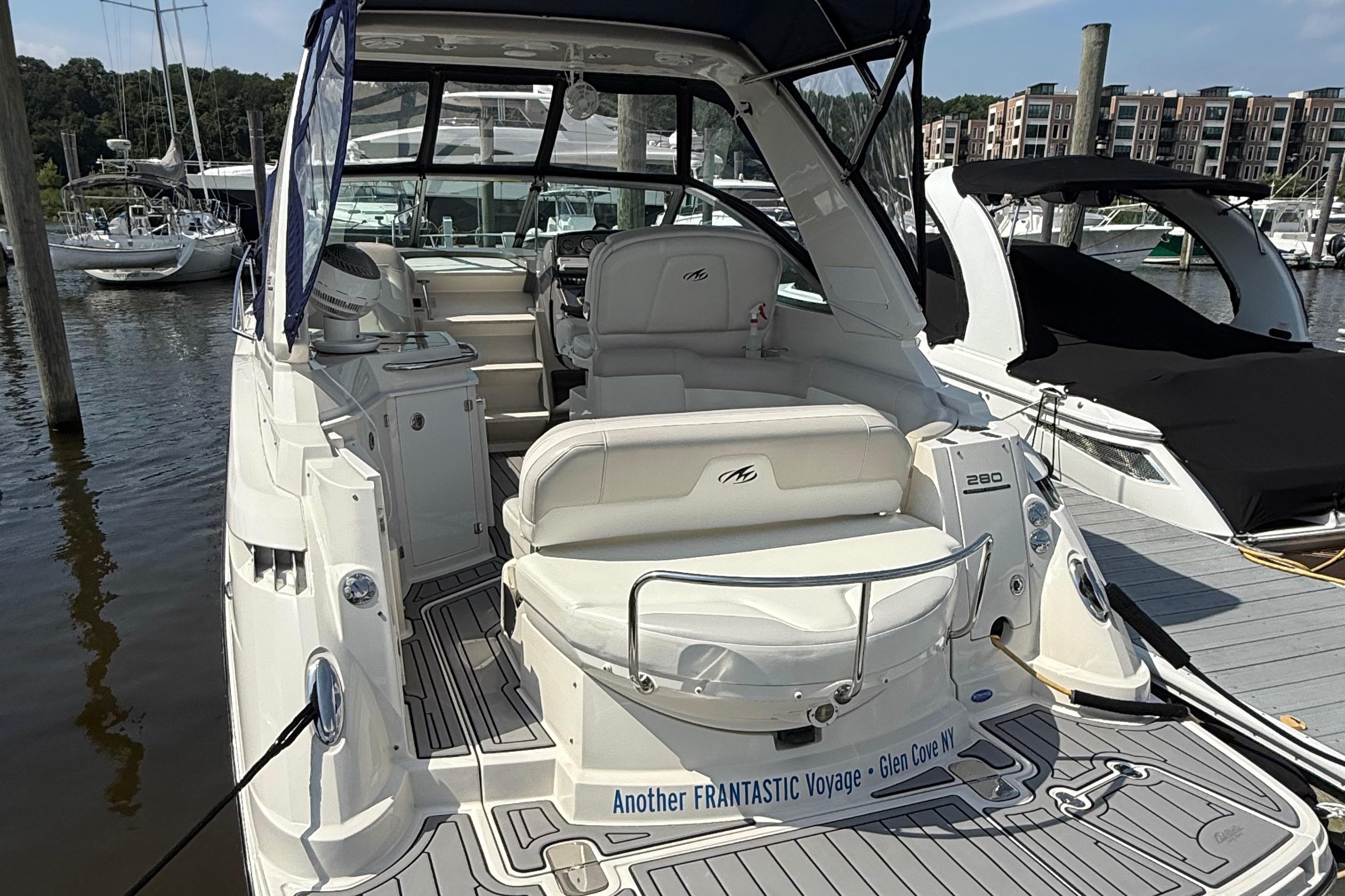 2009 Monterey 280 SCR boat docked at marina, featuring spacious seating and sleek design.
