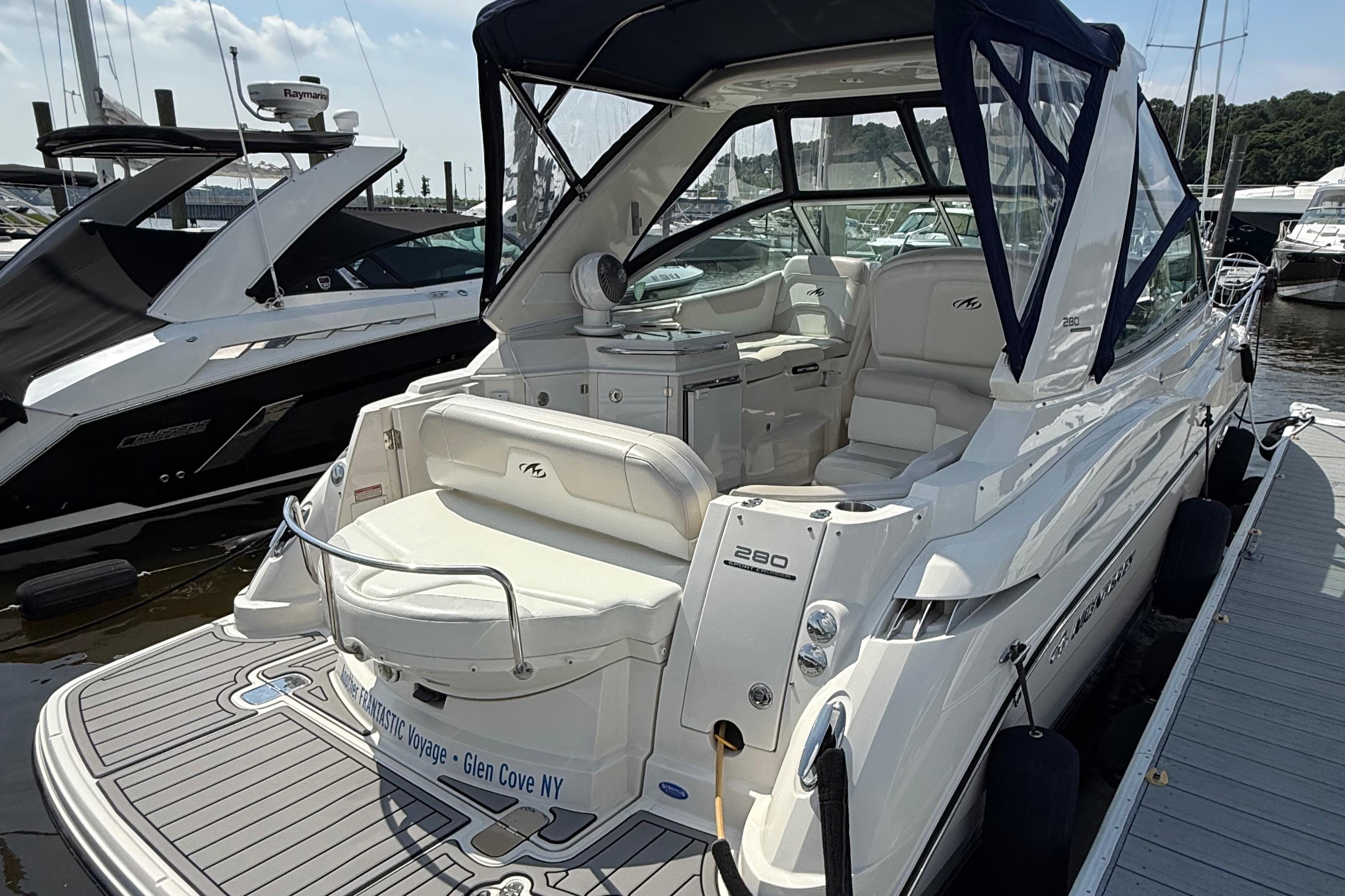 2009 Monterey 280 SCR boat docked, featuring spacious seating and sleek design.