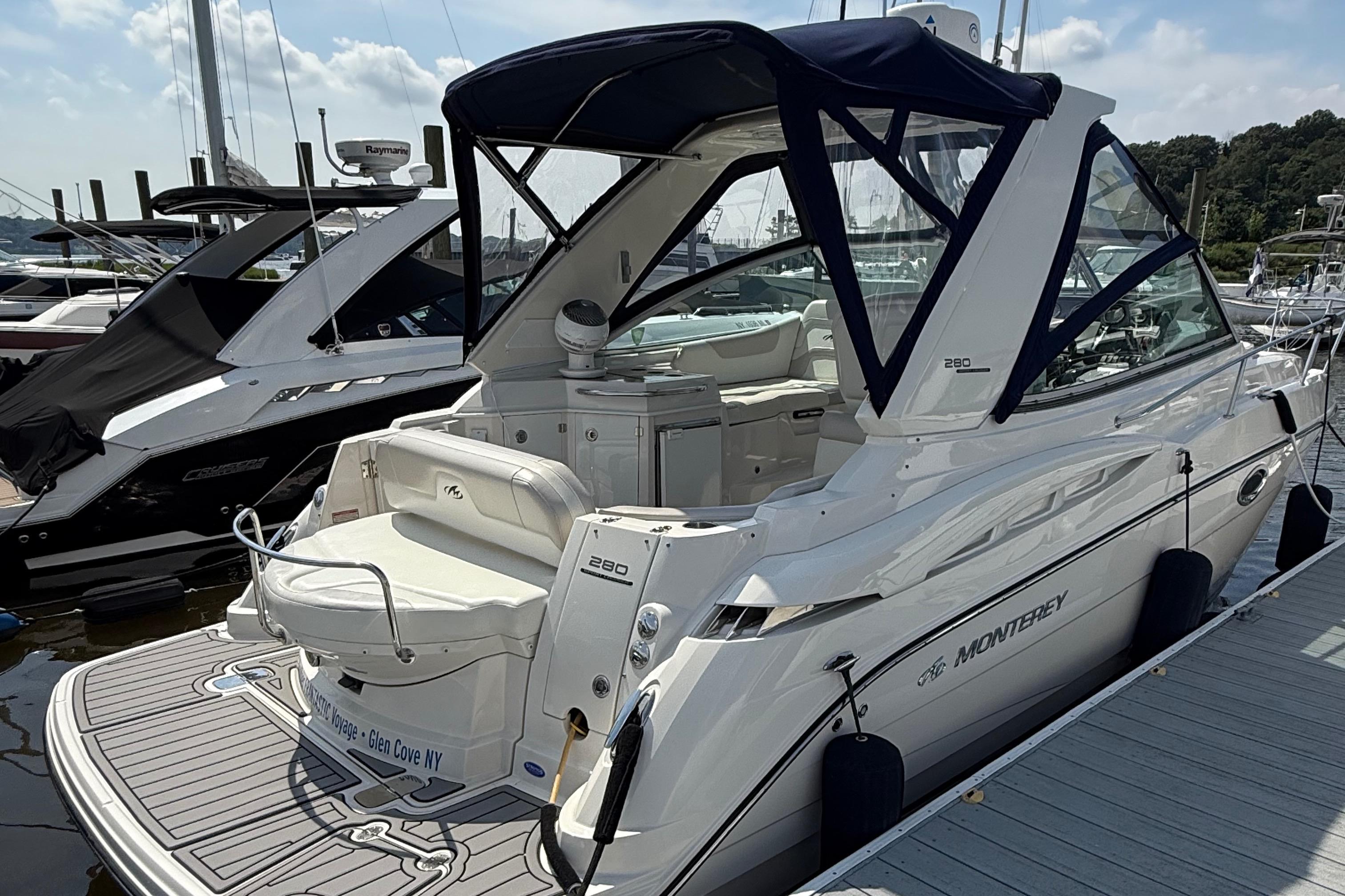 2009 Monterey 280 SCR boat docked at marina, featuring sleek design and spacious seating.