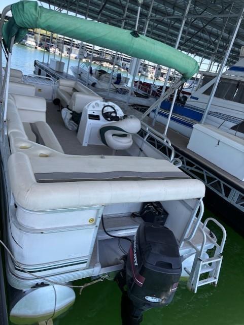2001 Monarch 240 pontoon boat docked under a covered marina.