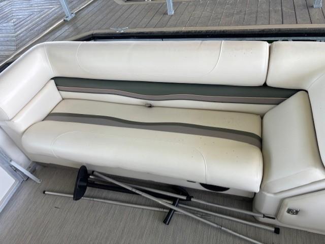 White cushioned seating on a 2001 Monarch 240 boat, with metal poles on the floor.