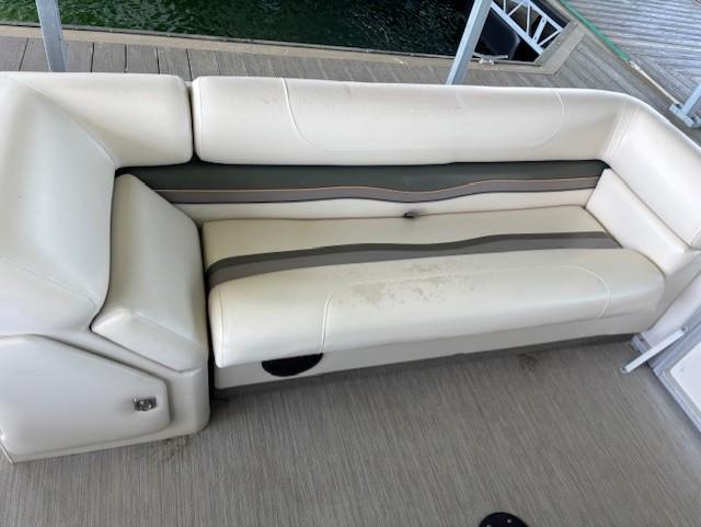 White cushioned seating on a 2001 Monarch 240 boat, docked by the water.