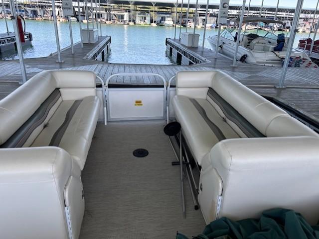 Interior of a 2001 Monarch 240 boat with white seating at a marina.