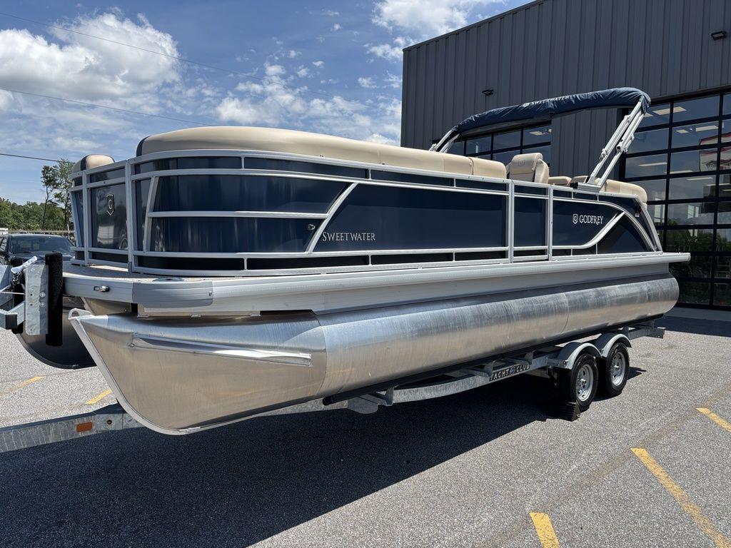 2025 Godfrey SWEETWATER 2286 SB pontoon boat on trailer, parked outdoors.