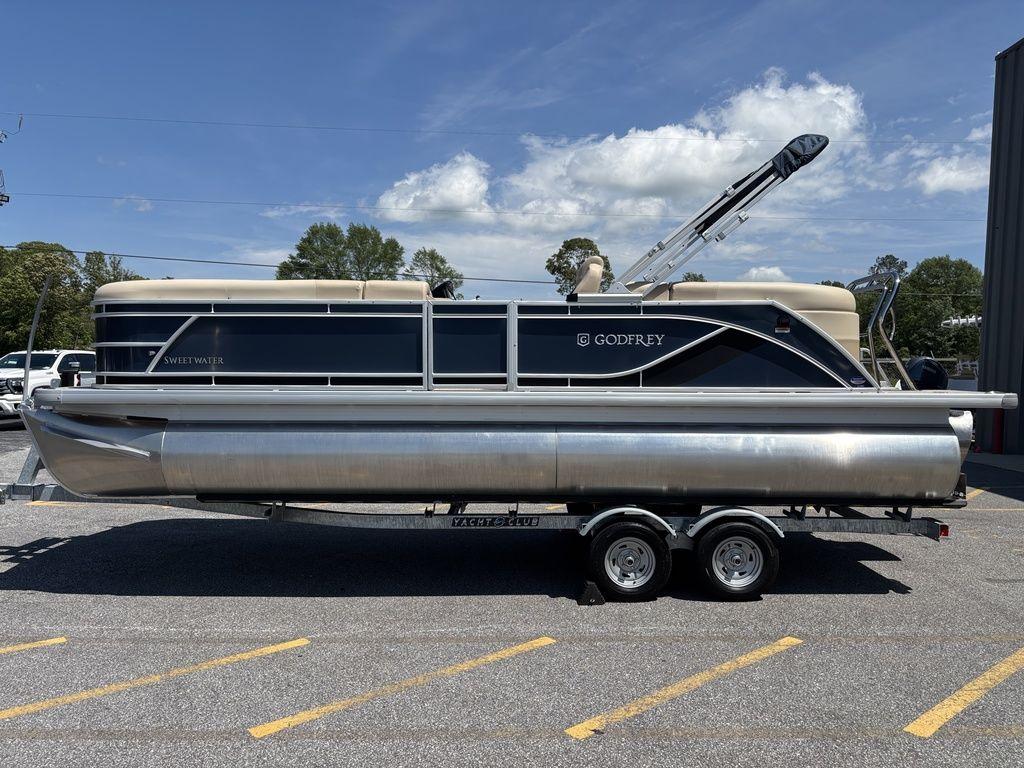2025 Godfrey SWEETWATER 2286 SB pontoon boat on trailer, parked outdoors.