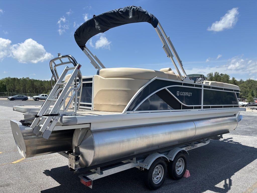 2025 Godfrey SWEETWATER 2286 SB pontoon boat on trailer, sunny day, blue sky.