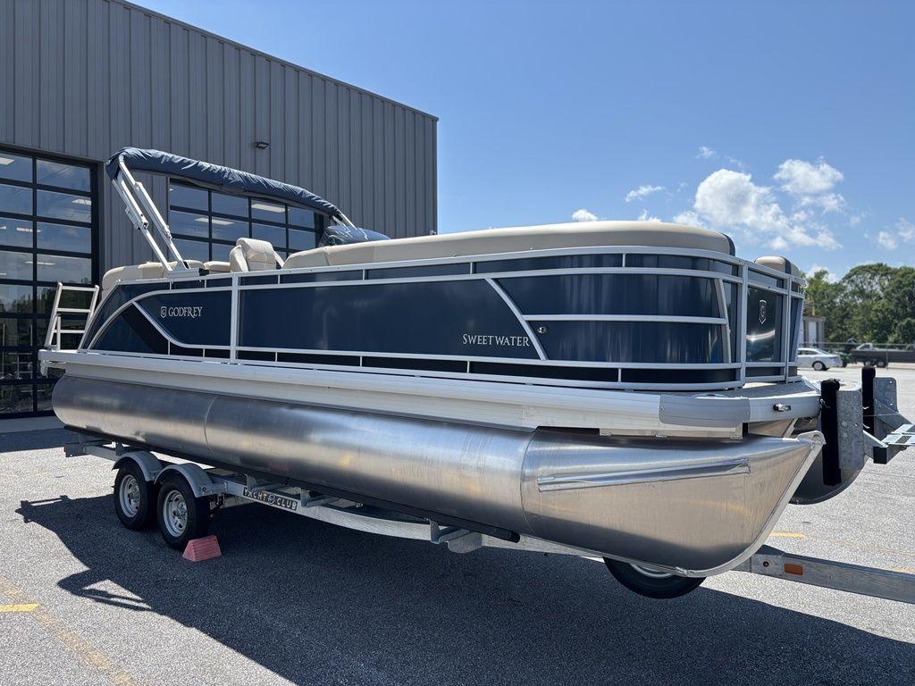 2025 Godfrey SWEETWATER 2286 SB pontoon boat on trailer, parked outdoors.