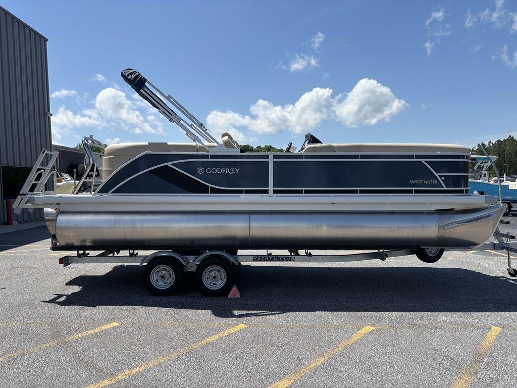 2025 Godfrey SWEETWATER 2286 SB pontoon boat on trailer, parked outdoors.