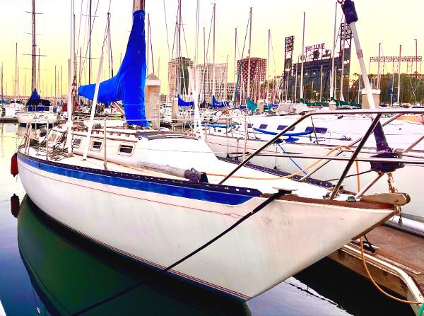 1978 Islander Sloop 36 docked at marina with blue sail cover.