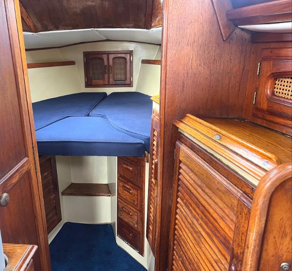 1978 Islander Sloop 36 cabin interior with wooden finish and blue cushions.