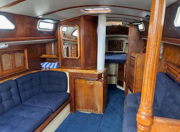 Interior of 1978 Islander Sloop 36 sailboat with wooden furnishings and blue upholstery.