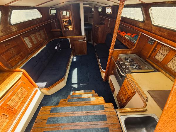 Interior of a 1978 Islander Sloop 36 sailboat, featuring wood finishes and compact kitchen.