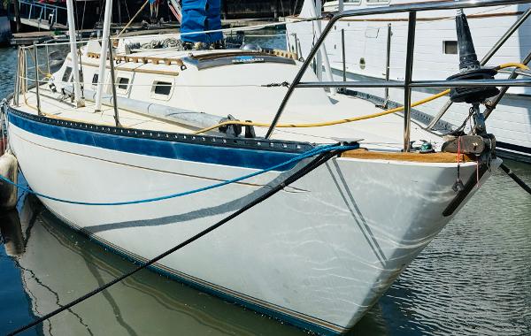 1978 Islander Sloop 36 sailboat docked in marina, side view.