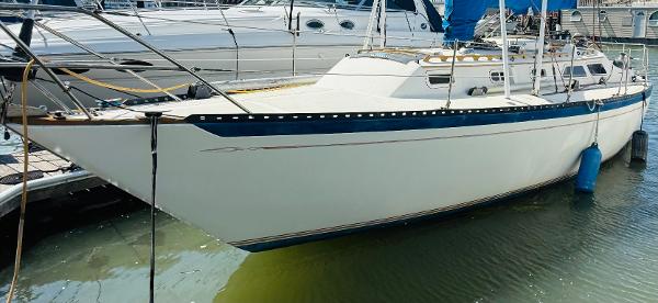 1978 Islander Sloop 36 sailboat docked in marina, white hull with blue accents.