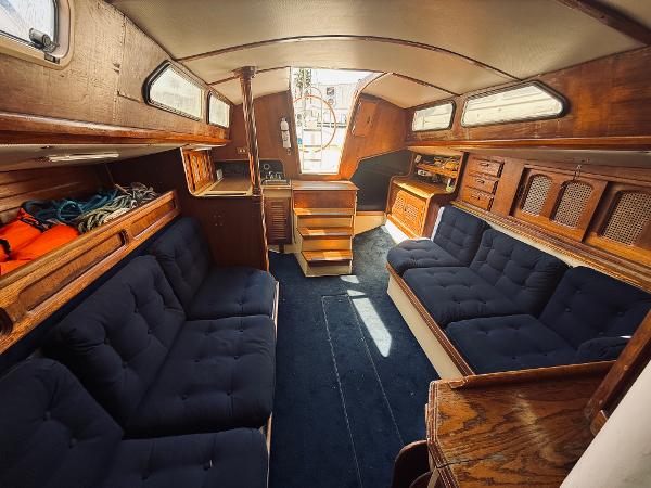 Interior of 1978 Islander Sloop 36 sailboat with wooden furnishings and blue upholstery.