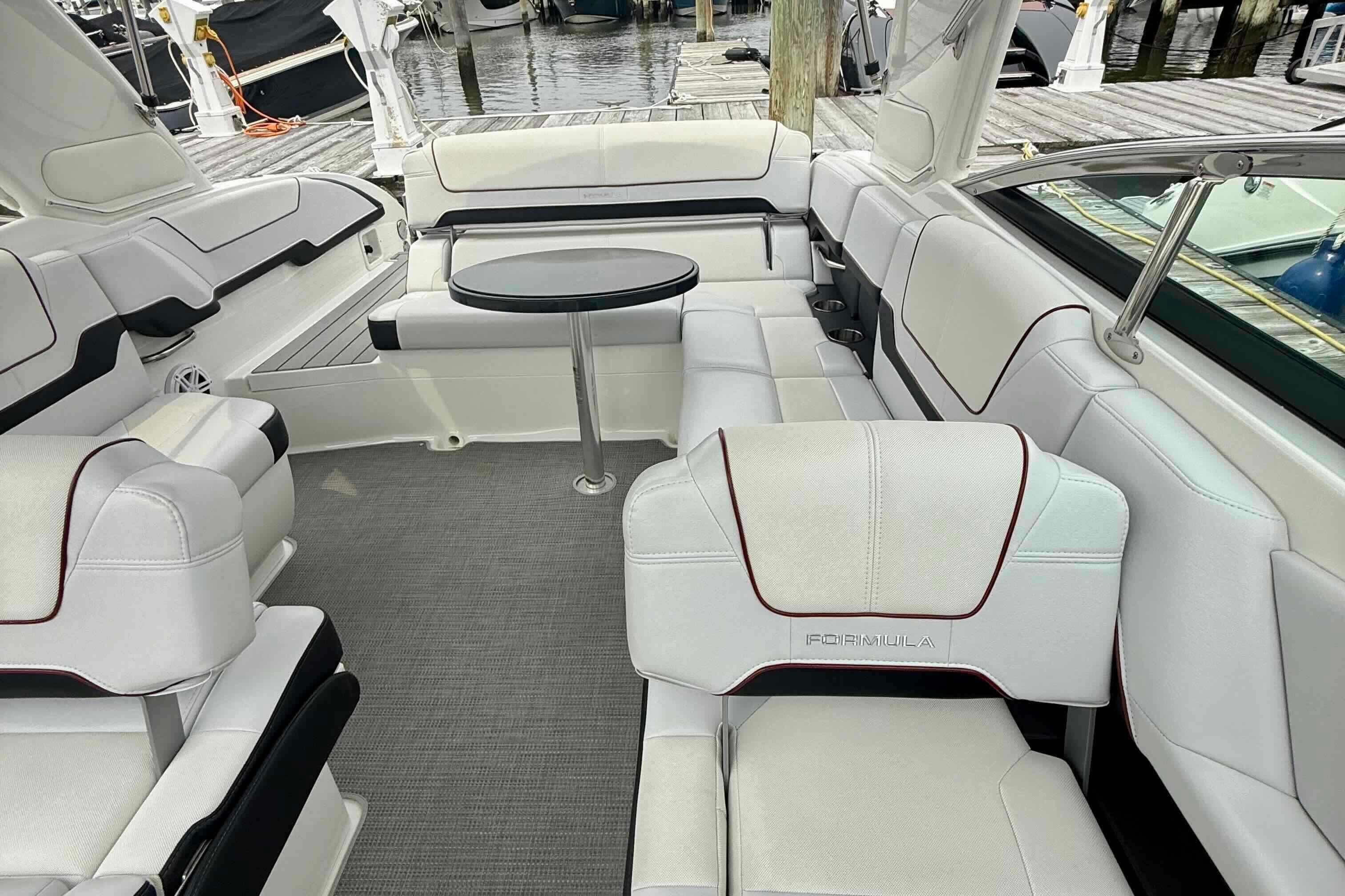 2020 Formula 290 Bowrider interior with white seating and round table, docked at marina.