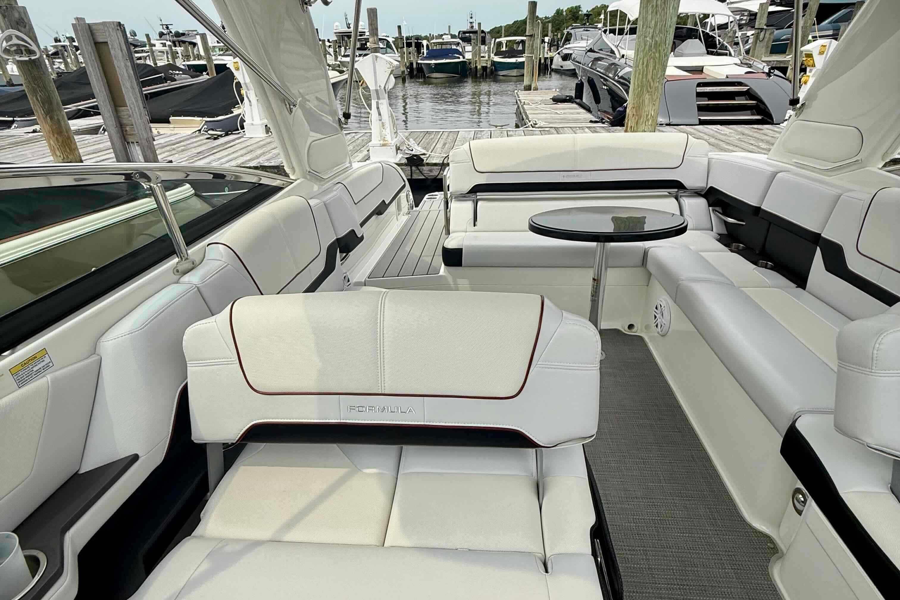 Luxurious 2020 Formula 290 Bowrider boat interior with white seating and a small table.